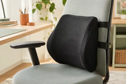 Coussin lombaire noir en mesh fixé au dossier d’une chaise de bureau par des sangles réglables